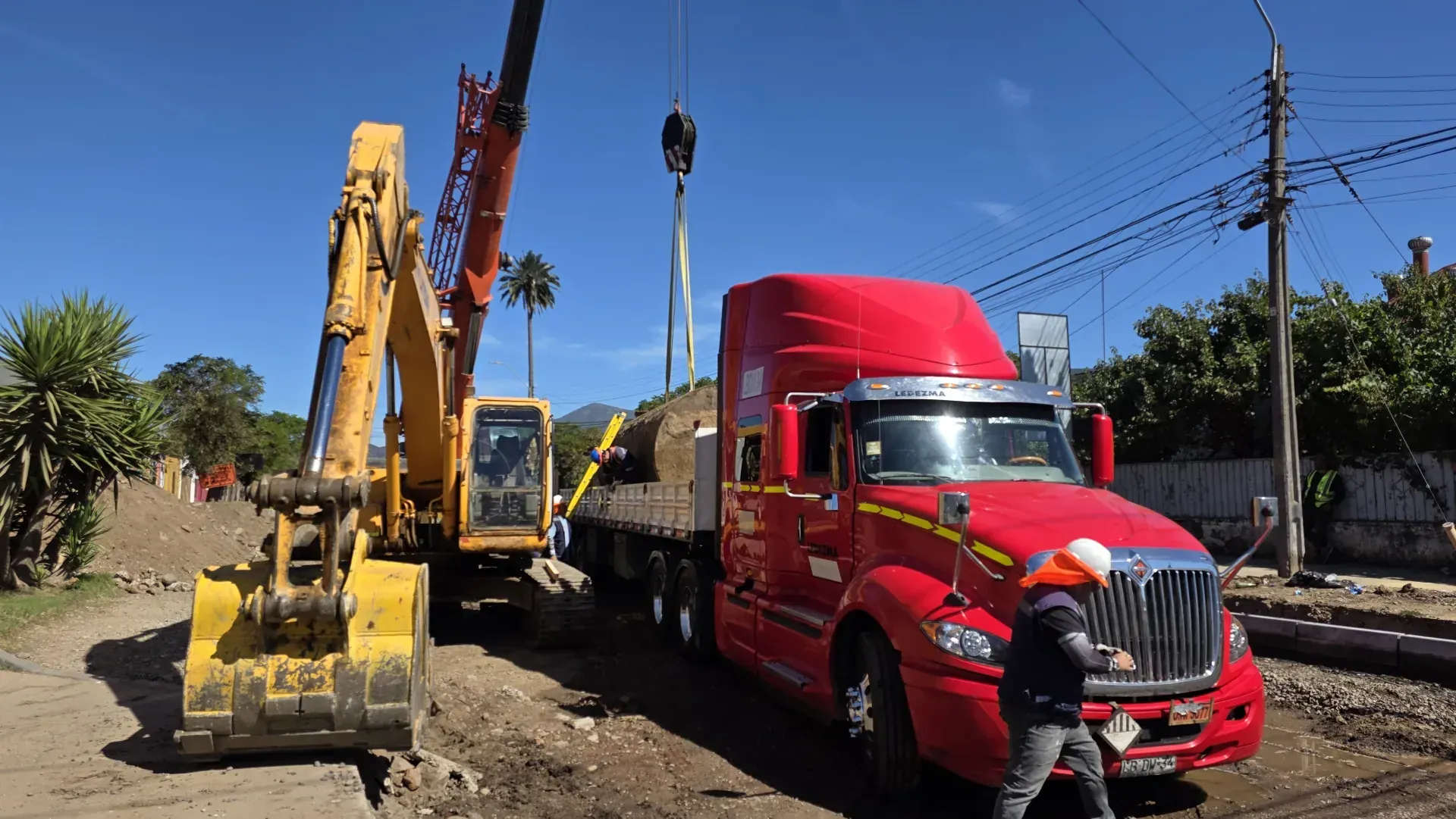 Grúa y excavadora cargando estanque