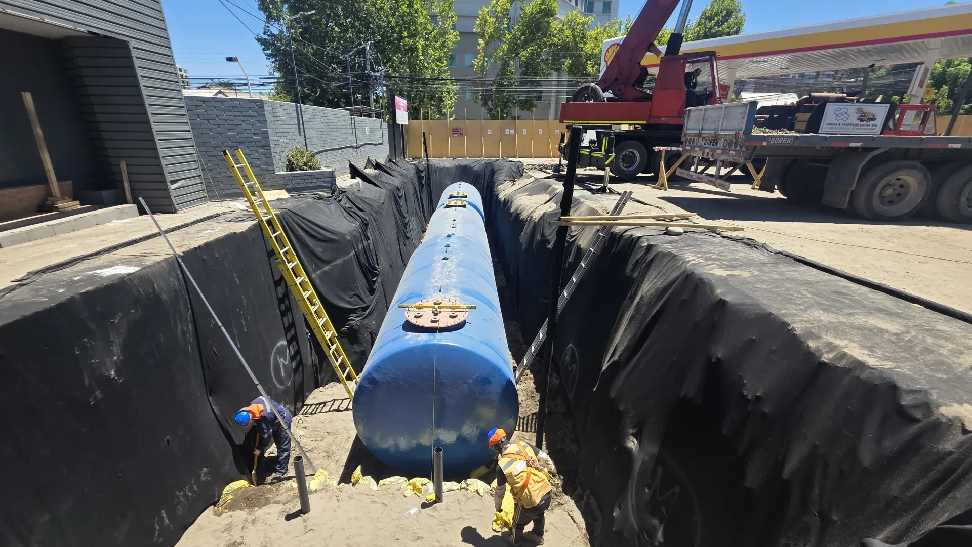 Cuadrilla nivelando tanque en zanja